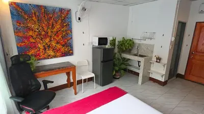 a living room with a painting on the wall at Lumphini Perfect Escape Sunny Rooftop EnSuite in Bangkok