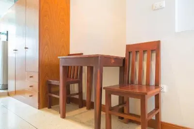 a wooden desk and two chairs in a room at Cloud no 5 Generous space Green n Quiet Heart BKK in Bangkok