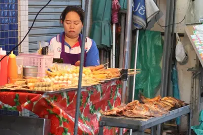 a woman standing in front of a food stand at Cloud no 5 Generous space Green n Quiet Heart BKK in Bangkok