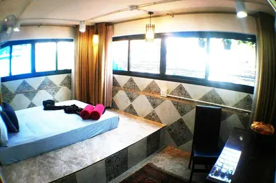 a room with a bed and a chair and windows at SKY 6 The Perfect Quiet Oasis BKK Center Near MRT in Bangkok