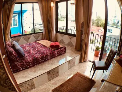 a bedroom with a bed and a balcony with windows at SKY 14 Vibrant street Cozy n Cool near center in Bangkok