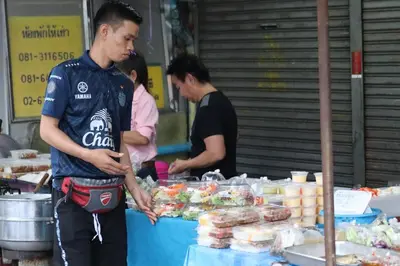 a man standing in front of a food stand at SKY 14 Vibrant street Cozy n Cool near center in Bangkok