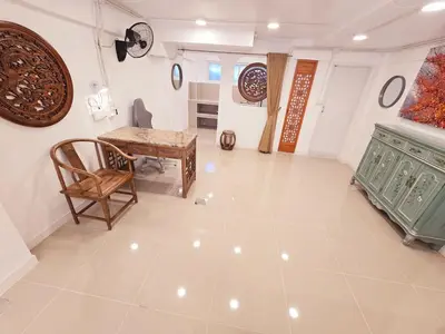 a living room with a table and a chair at Crane nest 1 Easy-peasy no stairs in Bangkok
