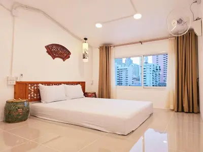 a bedroom with a white bed and a window at Crane nest 14 loft with views over Sathorn in Bangkok