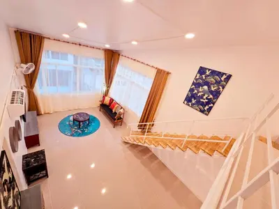 a living room with a staircase and a couch at Crane nest 14 loft with views over Sathorn in Bangkok