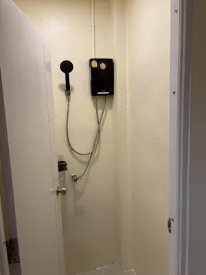 a room with a door with a phone on the wall at Nomad Yard Hostel in Bangkok