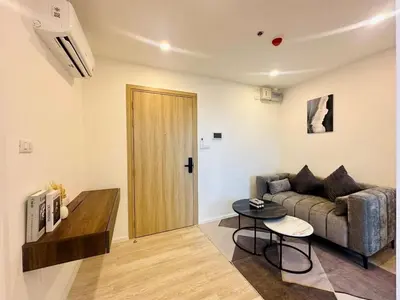 a living room with a couch and a table at The CLEV Riverline Chaophraya in Nonthaburi
