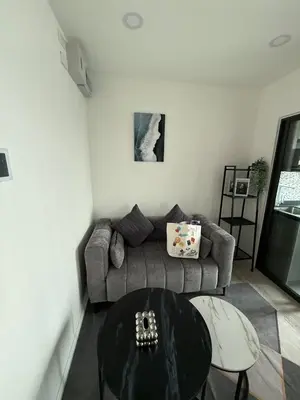a living room with a couch and a table at The CLEV Riverline Chaophraya in Nonthaburi