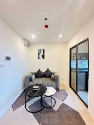 a living room with a couch and a table at The CLEV Riverline Chaophraya in Nonthaburi