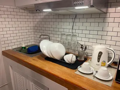 a kitchen counter with white dishes and a coffee maker at Lazy Nest at Impact Muangthong in Thung Si Kan