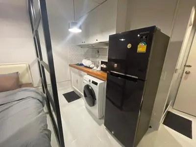 a small kitchen with a washing machine and a washer at Lazy Nest at Impact Muangthong in Thung Si Kan
