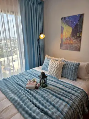 a bedroom with a large bed with a blue blanket at Modiz Modiza Sukhumvit R1 in Bangkok