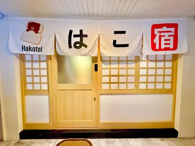 a room with two doors and signs on the wall at Hakotel in Bang Rak