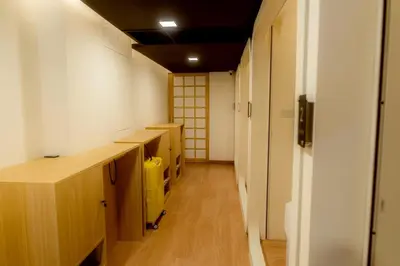 a room with wooden counters and a hallway with doors at Hakotel in Bang Rak