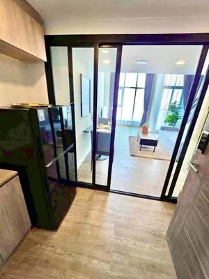 a living room with sliding glass doors in a house at Modiz Modiza Sukhumvit R3 in Bangkok
