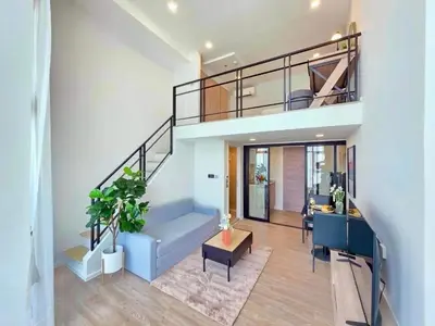 a living room with a blue couch and a staircase at Modiz Modiza Sukhumvit R3 in Bangkok