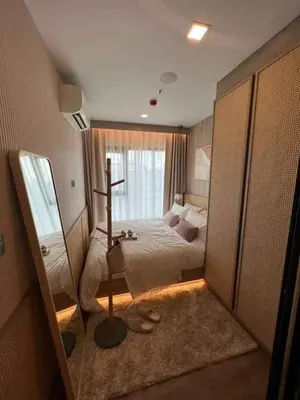 a bedroom with a bed and a cross on the floor at Modiz Modiza Sukhumvit R5 in Bangkok