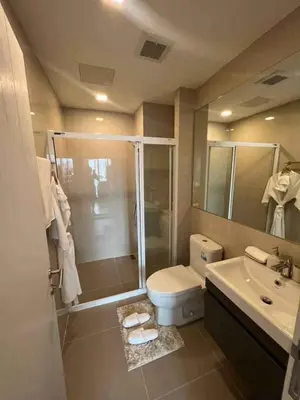 a bathroom with a shower and a toilet and a sink at Modiz Modiza Sukhumvit R5 in Bangkok