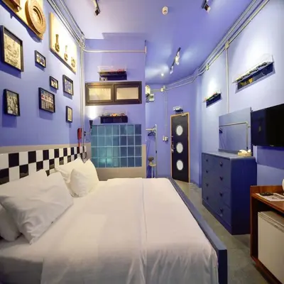 a blue bedroom with a large bed and a tv at Collection O Jasaen Stylish Unique Hotel in Bangkok