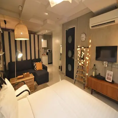 a living room with a bed and a couch and a tv at Collection O Jasaen Stylish Unique Hotel in Bangkok