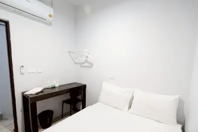 a bedroom with a bed and a desk with a phone at xx Mitr Inn Khaosan มิตร อินน์ ตรอกข้าวสาร in Bangkok