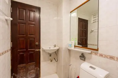 a bathroom with a toilet and a sink and a mirror at White Base in Bangkok
