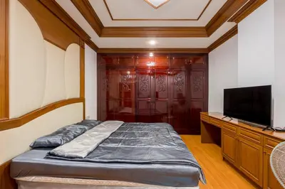 a bedroom with a bed and a flat screen tv at White Base in Bangkok
