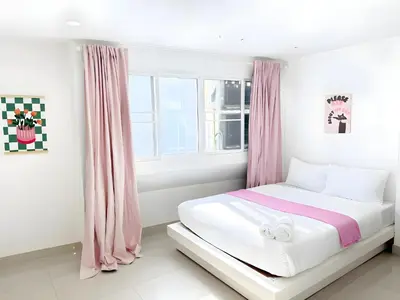 a white bedroom with pink curtains and a bed at XX Oh My Nap Nana Soi 3 - BTS Nana in Bangkok