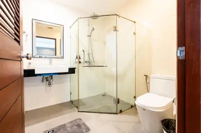 a bathroom with a glass shower and a toilet at XX Yon INN Sukhumvit Soi 4 - BTS Nana in Bangkok