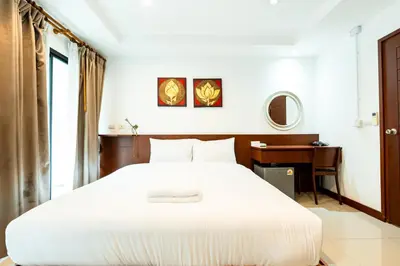 a bedroom with a large white bed and a desk at XX Yon INN Sukhumvit Soi 4 BTS Nana in Bangkok
