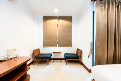 a room with two chairs and a desk and a window at XX Yon INN Sukhumvit Soi 4 BTS Nana in Bangkok