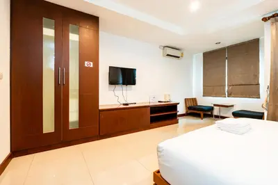 a bedroom with a bed and a tv and a desk at XX Yon INN Sukhumvit Soi 4 BTS Nana in Bangkok