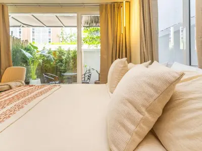 a bedroom with a large bed with a large window at Studio room with private garden in Center Sathorn in Bangkok
