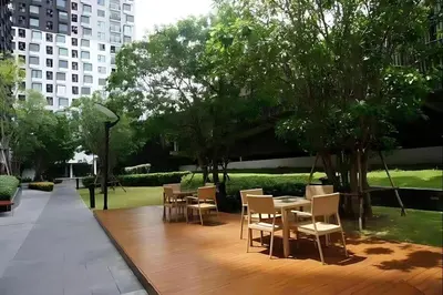 a patio with tables and chairs in a park at Skyline View 1 Bedroom Near RCA, Thonglor And Nana in Bangkok
