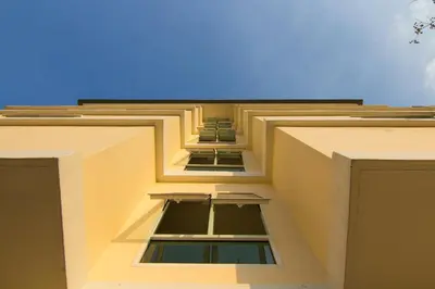 a building with two windows and a blue sky at Dae Ma Place in Nonthaburi