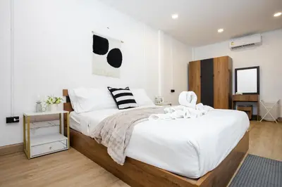 a bedroom with a large bed with white sheets at Urban Muji Oasis Ratchada-Lat Phrao Chatuchak MRT in Bangkok