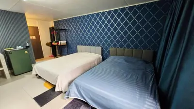 a bedroom with two beds and a blue wall at อิมแพ็ค เมืองทองธานี ห้องเช่ารายวัน เมืองทอง popular condo C4 in Nonthaburi