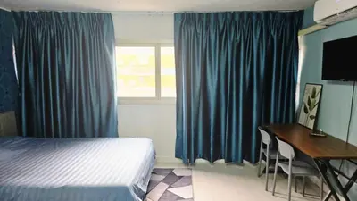 a bedroom with a bed and a desk and a window at อิมแพ็ค เมืองทองธานี ห้องเช่ารายวัน เมืองทอง popular condo C4 in Nonthaburi