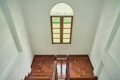 a stair case with a window in a white room at Baan Suanpak in Bangkok