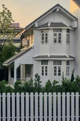 a white fence in front of a white house at Baan Suanpak in Bangkok