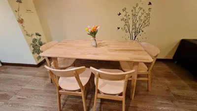 a wooden table with chairs and a vase of flowers on it at Comfort 1BR 2 King Beds, Best Value Stay, near Bts Nana in Bangkok