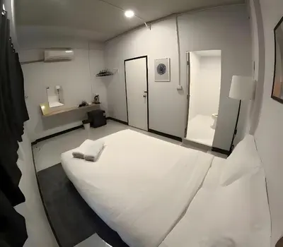 a small room with a white bed and a mirror at xx GO INN BTS Ari - โกอินอารีย์ in Bangkok