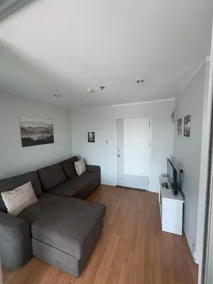 a living room with a couch and a television at Minimalist Condo in Pinklao in Bangkok
