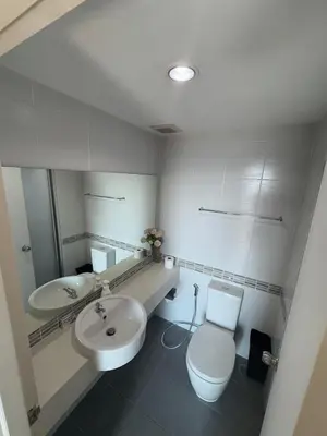 a white bathroom with a toilet and a sink at Minimalist Condo in Pinklao in Bangkok