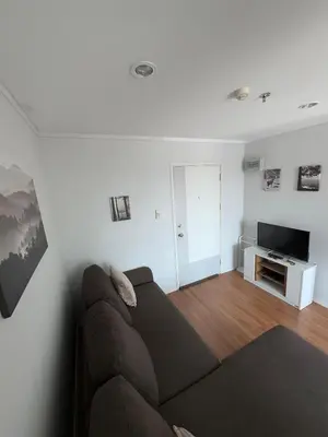 a living room with a couch and a television at Minimalist Condo in Pinklao in Bangkok