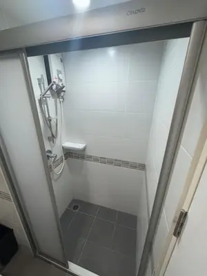 a shower in a bathroom with a glass door at Minimalist Condo in Pinklao in Bangkok
