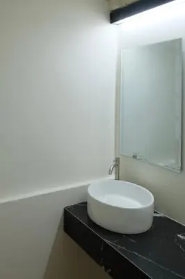 a white sink on a black counter in a bathroom at The beeroom by BoonmeeApt in Sathani Sam Sen