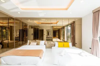 two beds in a room with mirrors at Modern Luxury Poolhaus with Lift in Khlong Toei