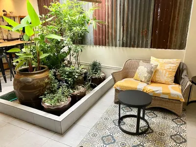 a living room with potted plants and a couch at Bali Style Rooftop Apartment in Bangkok