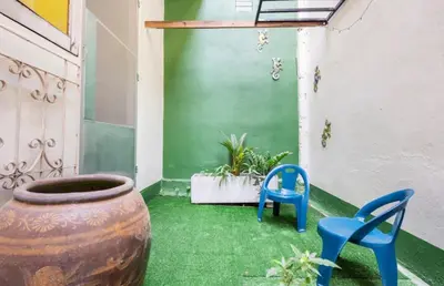 a patio with a large vase and two blue chairs at Bali Style Rooftop Apartment in Bangkok
